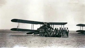 Sepia Images: Biplane with crew and arabs in the desert, Iraq