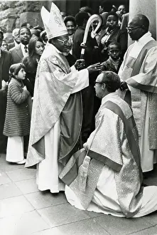 Emeritus: Bishop Desmond Tutu standing and wearing religious
