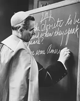 1145: Bishop Fulton Sheen writing on blackboard during