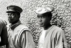 Pebbled: Two black men standing against a pebbled wall