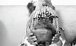 Healers: Black and white photo of sangoma drinking from