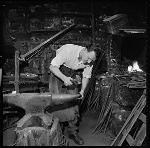 Tamar: A blacksmith working at an anvil. The location