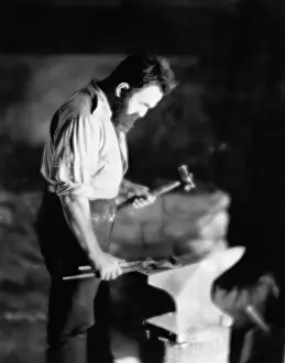 Pounding: Blacksmith working metal on anvil