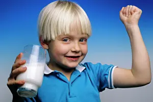 Flexing: Blond Boy Holding a Glass of Milk and Making a