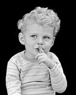 Shush: Blond Boy Holding Index Finger to Lips Be Quiet Gesture