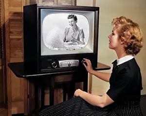 Singular: Blonde Woman Turning Dial on Tv Set Watching Program