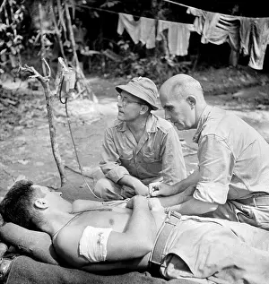 Buna: Blood Transfusion. A wounded man behind ?
