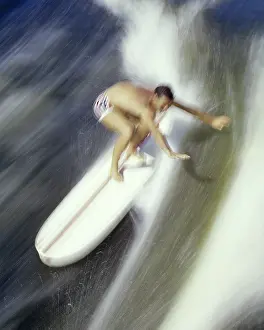 Surfer: Blurred Action of Athletic Man Standing Riding