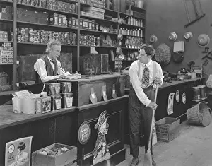 Clean Up: Boss watching employee sweeping floor in store