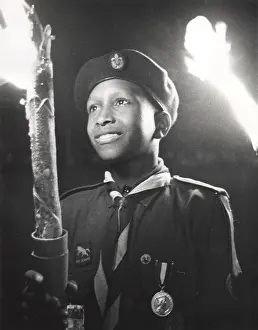 Nassau: Boy of 3rd Bahamas Scout Troop in torchlight parade