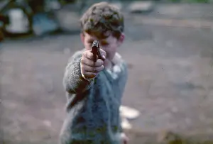 Boy aims a gun at the camera in West London