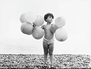 Pebbly: Boy with balloons at the seaside