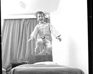 Bouncing: Boy bouncing up and down on a bed