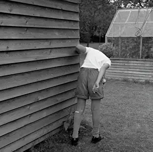 Underage: Boy with cigarette behind the garden shed