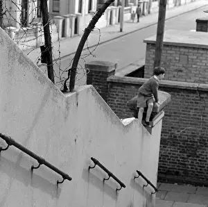 Gatepost: Boy climbing on a wall