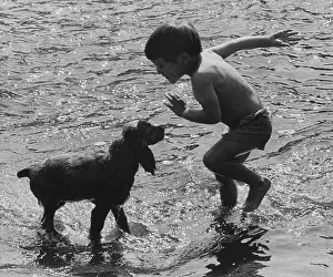Silhouetted: Boy and dog at the seaside