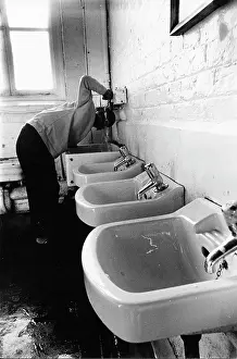 Taps: Boy drinking from a tap in the school toilets