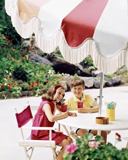 Straws: Boy and Girl with Cool Drinks at Table with Large Umbre