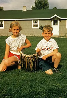 Rewarding: Boy and Girl Looking at Camera Displaying Fish