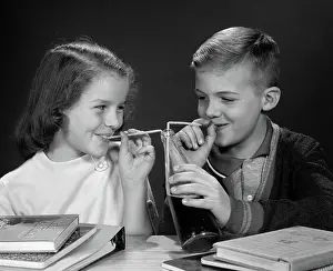 Straws: Boy and girl sharing single bottle of soda with