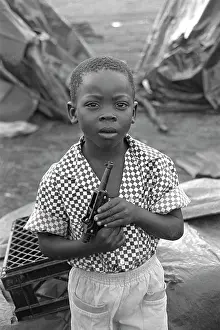 Tembisa: Boy with gun outside temporary homes at Oakmoor, in