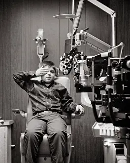 Pre Teen: Boy with Hand over one Eye Taking Vision Test
