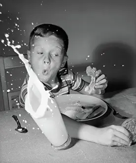 Mishap: Boy having lunch knocking over milk reaching