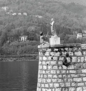 Imitating: Boy kneeling in front of a religious statue