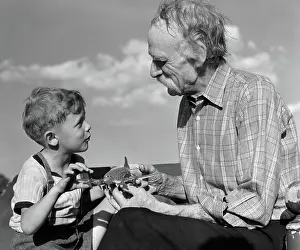 Grandsons: Boy looking at model propeller plane with grandfather