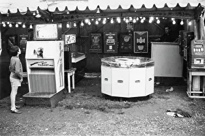 Boy looking at shooting game in fairground arcade