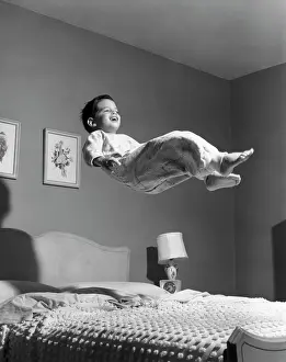 Bedspread: Boy in pajamas elevated above bed