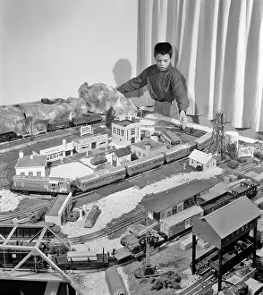 Rewarding: Boy Playing with Model Train Set and Toy Village