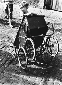 Classroger: Boy playing with pram in North Kensington