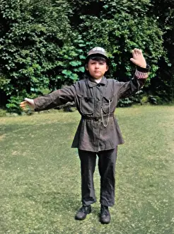 Pretending: Boy in policeman's uniform in a garden