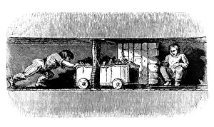 Smaller: Boy pushing a truck loaded with coal from the