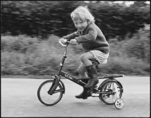 Wellies: Boy riding bicycle with stabilisers