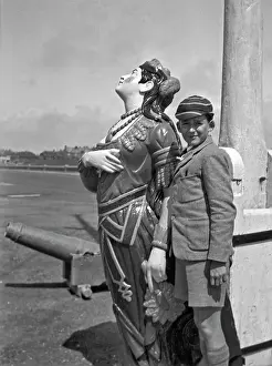 Figurehead: Boy in school uniform with figurehead at seaside
