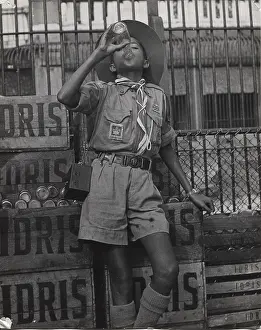 Crates: Boy scout drinking from a bottle of Idris, Mauritius