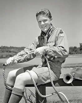 Thrifty: Boy Scout Tying Knots in Rope Smiling Looking
