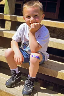 Adhesive: Boy Sitting on Steps with Adhesive Bandage on