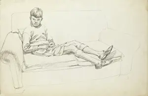 Lounging: Boy sitting on a two-seat sofa