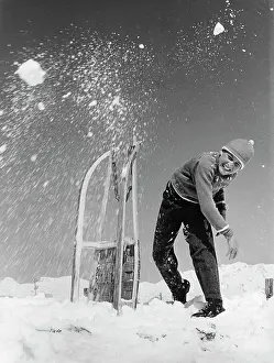 Freizeit: Boy with sleigh throws snowball