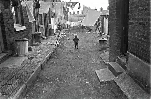 Slums: Boy in slum housing yard