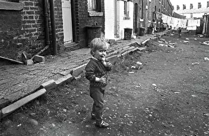 Slums: Boy in slum housing yard