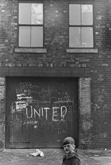 Shabby: Boy standing near run-down building