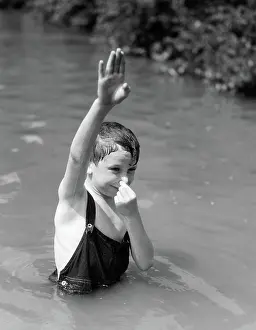Pre Teen: Boy wearing overalls as bathing suit standing