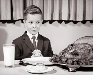 Hungrily: Boy Wearing Suit and Tie Sitting at Table