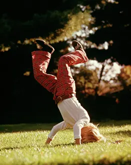 Somersault: Boy White Shirt Plaid Pants Standing on Head Upside Down