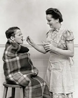 Dosage: Boy Wrapped in Blanket given a Spoonful of Medicine