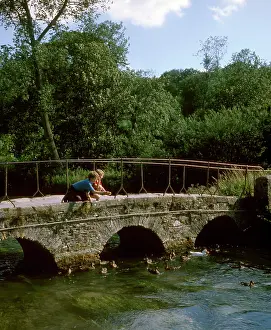 Bibury: Two boys on a bridge, feeding ducks, Bibury, Gloucestershire